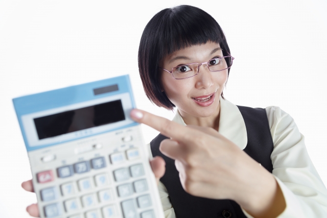 電卓に表示された金額を指さして見せてくる女性　写真