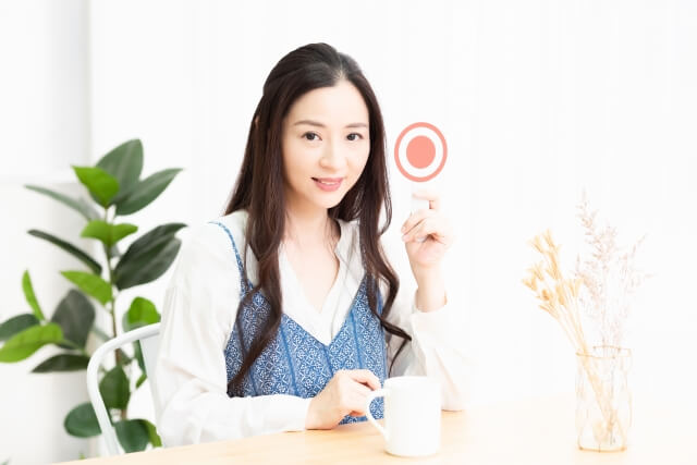 ○のプラカードを持つ女性　写真